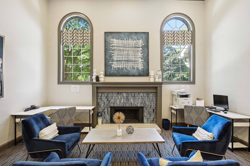a living room with blue chairs and a fireplace