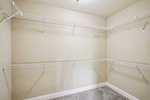 Empty white closet with shelves and hangers.