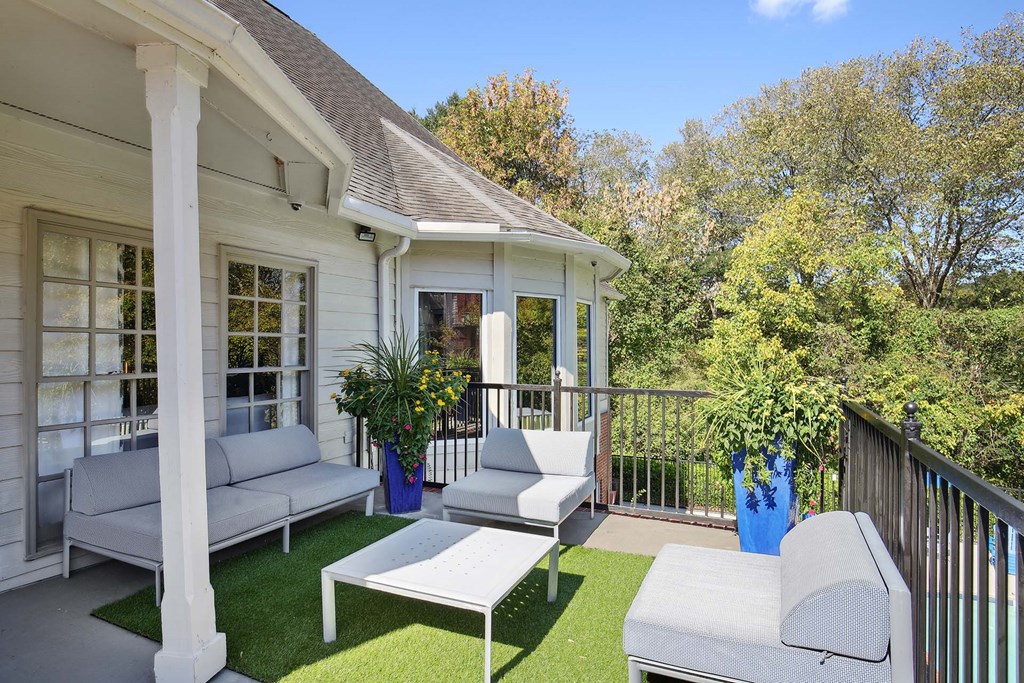 a patio with two couches and a table on a balcony