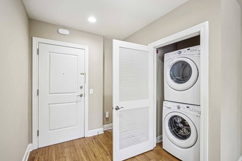 A white door is open to a laundry room with a washer and dryer.