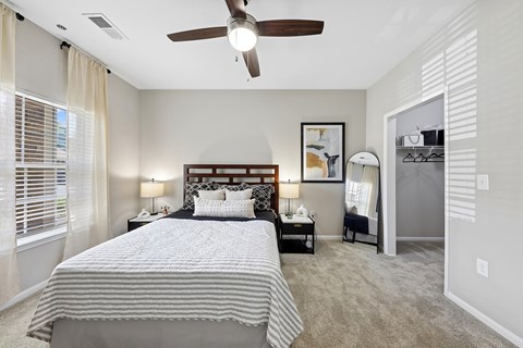 A bedroom with a large bed and a ceiling fan.