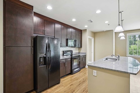 A kitchen with black appliances and wooden cabinets.