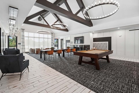 A large room with a pool table and chairs.
