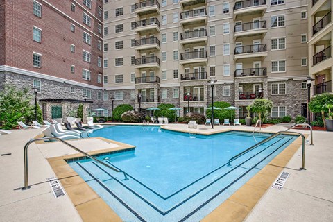 A large swimming pool in front of apartment buildings.