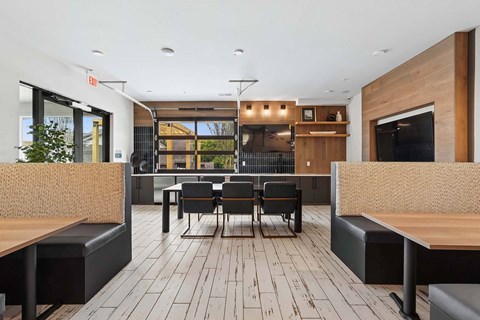 A modern dining area with a long table surrounded by black chairs and wooden benches.