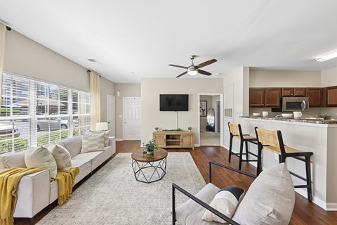 A living room with a white couch and a yellow throw blanket.