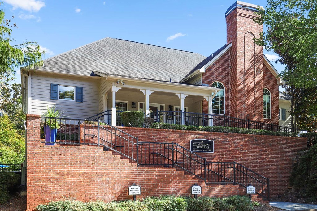 the front of a brick house with stairs and a porch