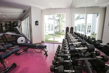 a gym with weights on the floor and windows