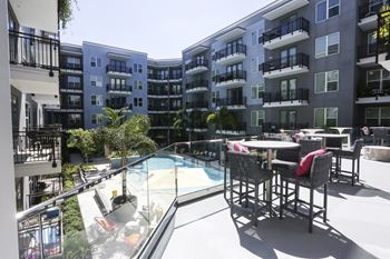 an outdoor patio with a pool and an apartment building