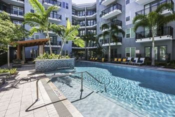 a large swimming pool in front of an apartment building