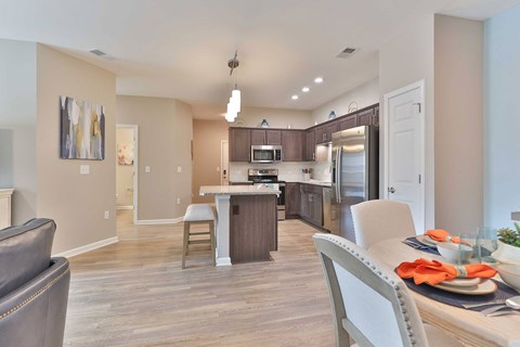 A modern kitchen with a dining table set for two.