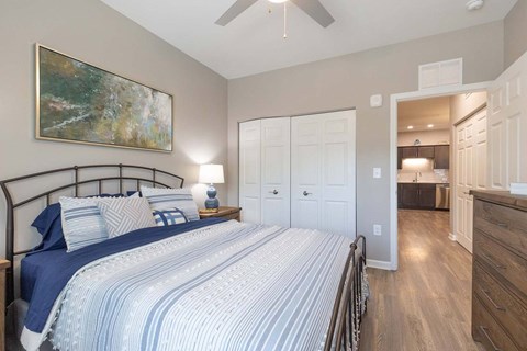 A bedroom with a large bed and a painting on the wall.