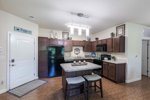 A kitchen with a table and chairs in the middle of it.