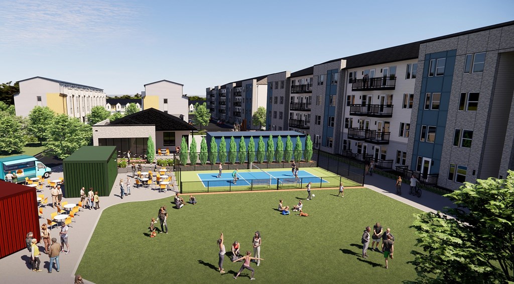 an aerial view of an apartment complex with people playing on a lawn