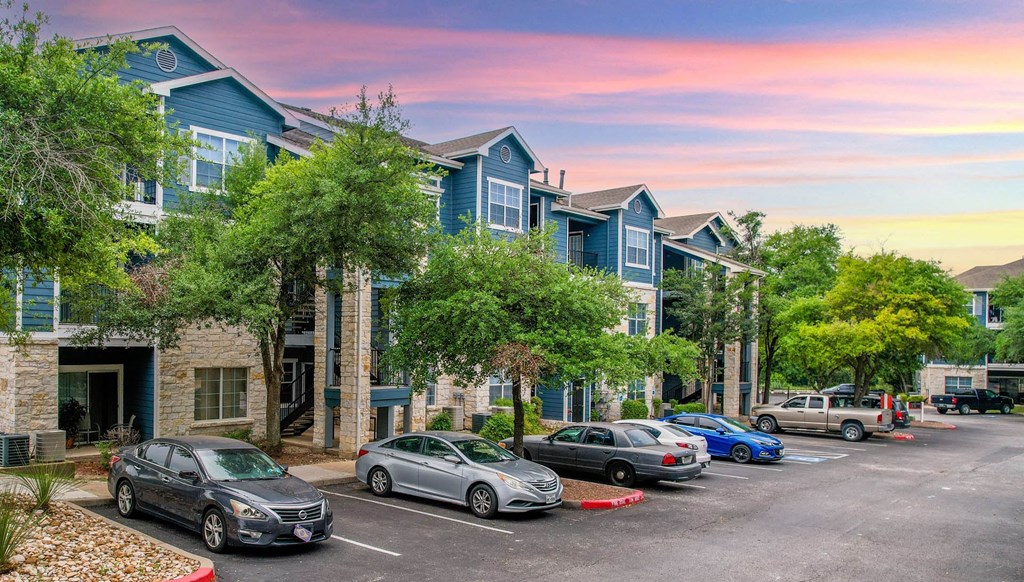 a row of town houses with cars parked in front of them