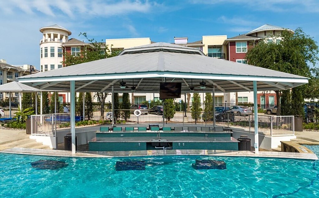 a swimming pool with a covered pavilion and a poolside jacuzzi
