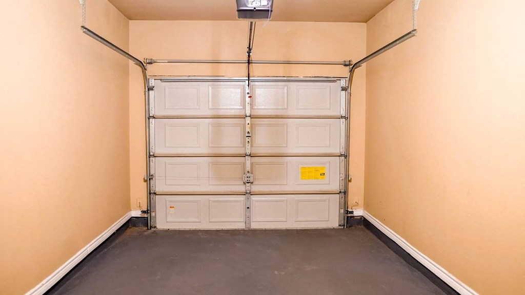 a garage with white doors and a black floor