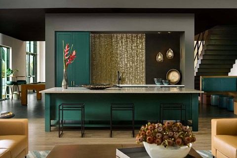 a kitchen with a green counter and a bowl of flowers