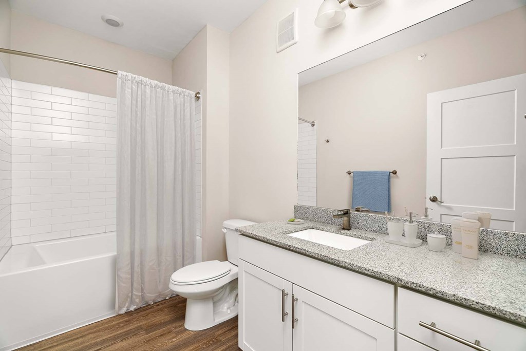 A white bathroom with a toilet, sink, and shower.