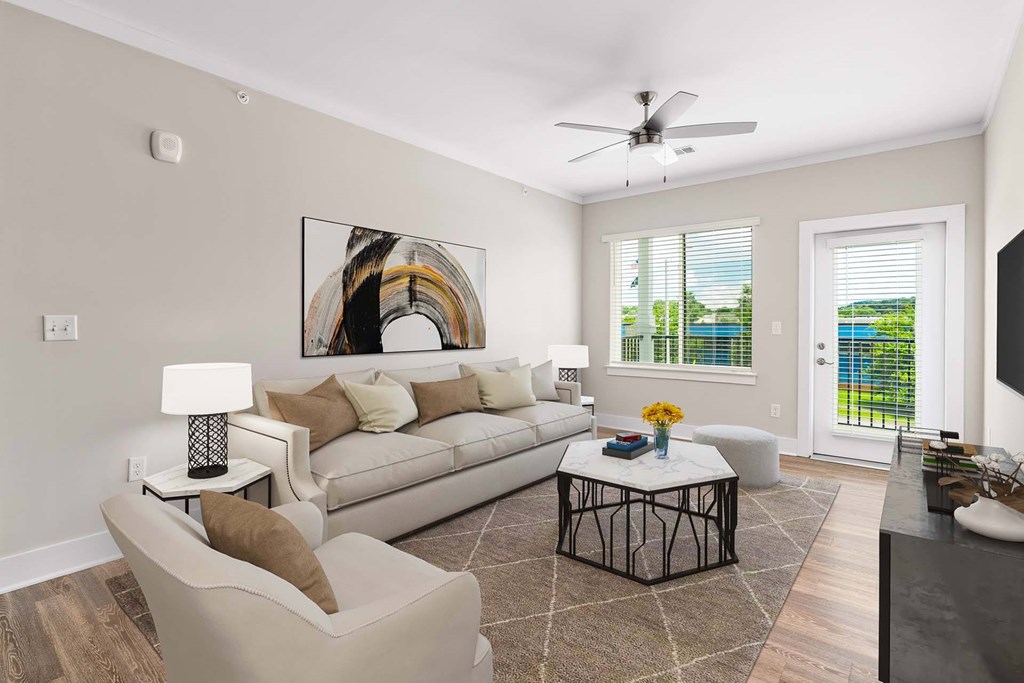 A living room with a white couch, a coffee table, and a painting on the wall.