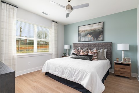 A bedroom with a large bed and a ceiling fan.