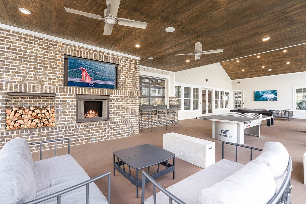 the living room has a brick fireplace and a pool table