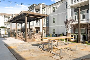 Outdoor Biergarten styled with decorative lighting, plenty of seating and covered grilling stations