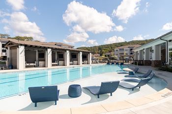 Sundeck with lounge chairs, tables with chairs, and four cabanas