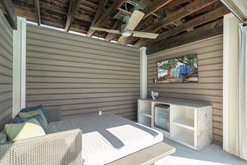 Sundeck with lounge chairs, tables with chairs, and four cabanas