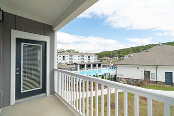 a balcony with a view of a pool and some buildings