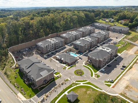 Aerial view of apartment complex with green spaces, walking paths, and pools in West Knoxville, TN.