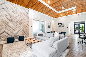 A living room with a white couch and a wooden ceiling.
