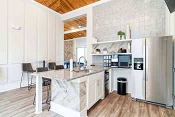 A kitchen with a marble countertop and stainless steel appliances.