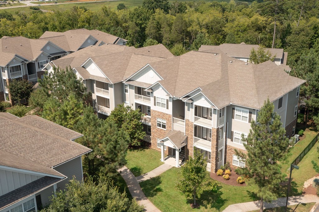 an aerial view of an apartment building surrounded by trees