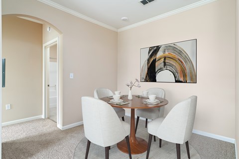 A dining room with a round table and chairs.