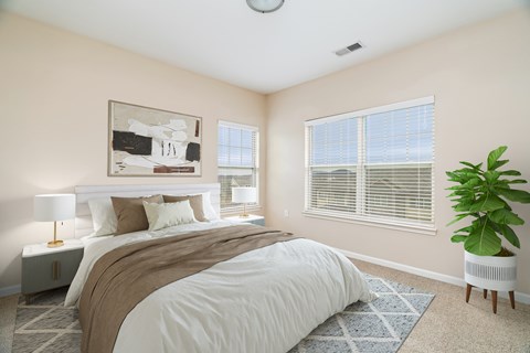 A bedroom with a large bed and a plant.
