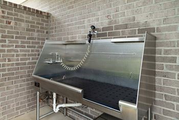 A stainless steel industrial machine with a glass top and a pipe running through it.