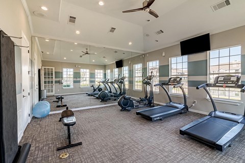 a gym with exercise equipment and windows in a building at Orion Prosper, Prosper, TX, 75078