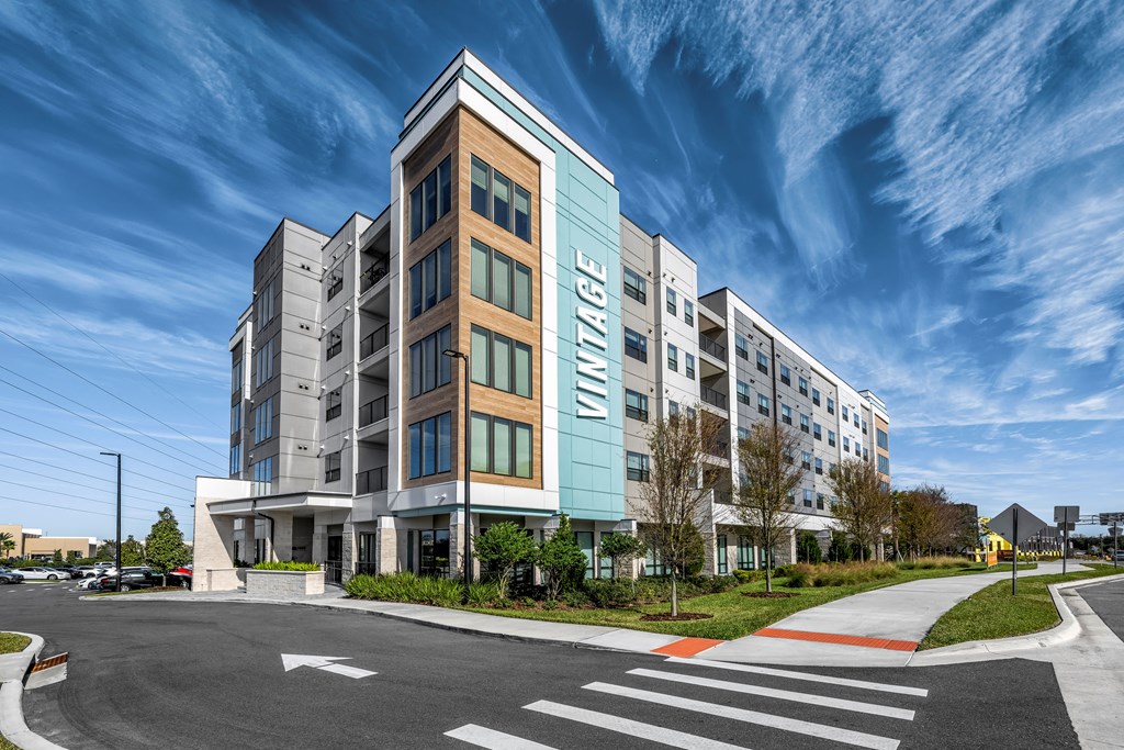 a large apartment building with a blue sky in the background
