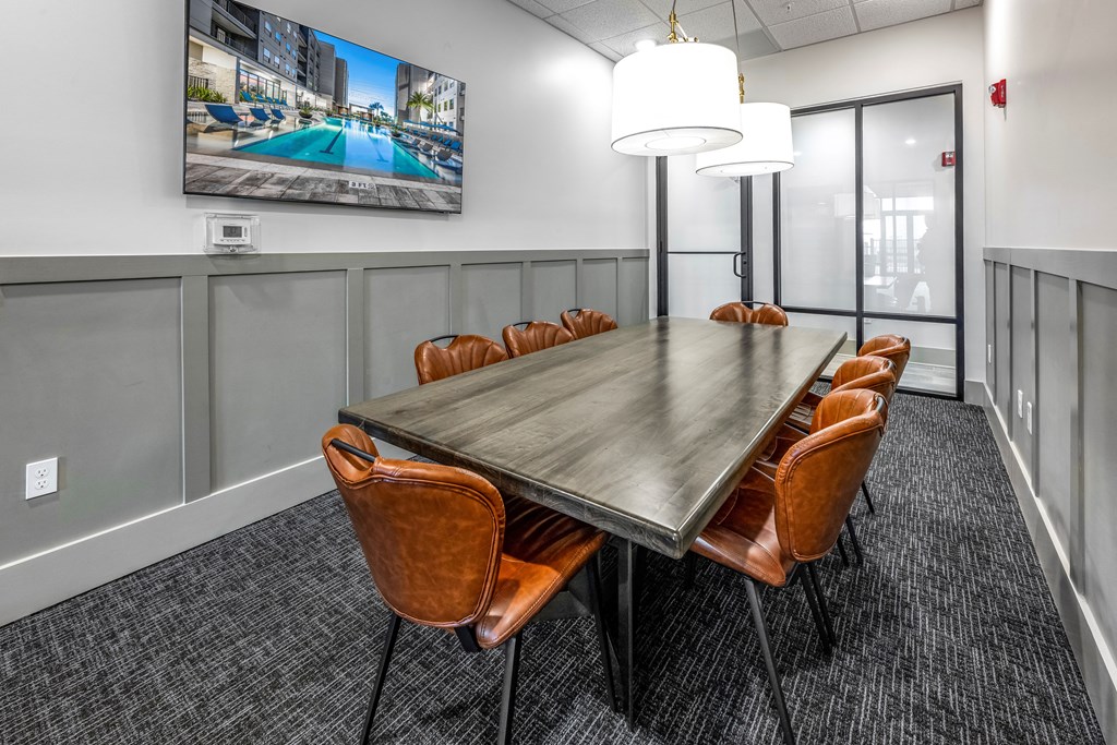 a conference room with a long table and chairs and a tv