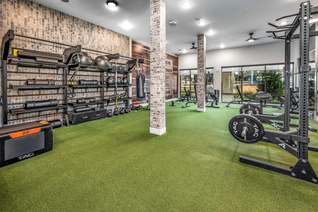 a home gym with weights and equipment and a brick wall