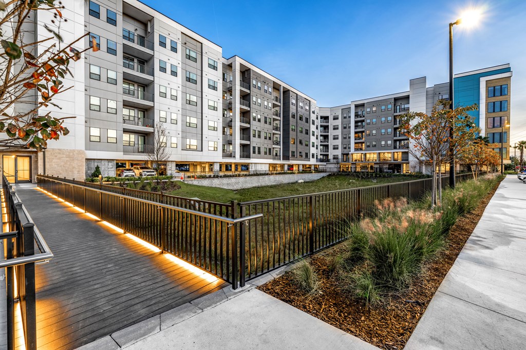 an outdoor courtyard with a fence and an apartment building