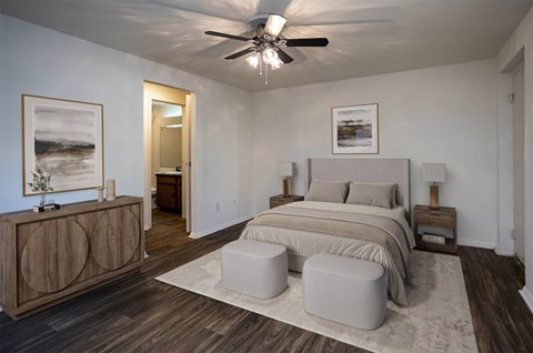 A bedroom with a bed, nightstands, and a ceiling fan.