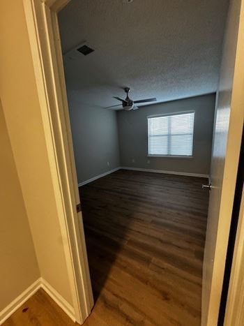 A room with a ceiling fan and a window.