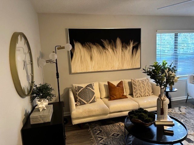 A living room with a white couch, a coffee table, and a large painting on the wall.