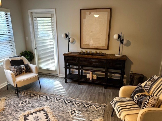 A living room with a rug, a chair, a sofa, and a fireplace.