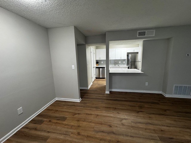 A room with wooden flooring and white walls.
