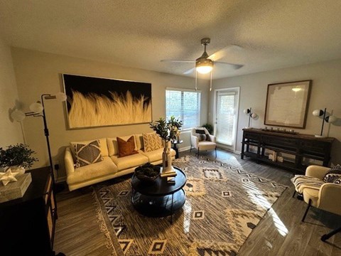 A living room with a white couch, a coffee table, and a painting on the wall.