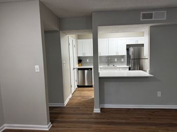 A kitchen with a refrigerator, sink, and cabinets.