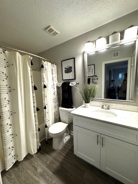 A bathroom with a white toilet, sink, and shower curtain.